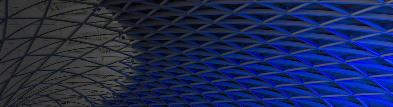 Abstract geometric ceiling pattern illuminated with blue lighting.