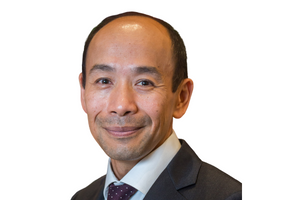 Head-and-shoulders professional portrait of Darren Yip wearing a collared shirt and blazer, facing the camera against a plain light background