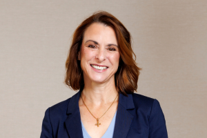 Head-and-shoulders professional portrait of Diona Raw wearing a blazer and light top, facing the camera against a plain light background
