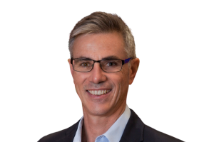  Head-and-shoulders professional portrait of Andrew Jones wearing glasses and a collared shirt with a blazer, facing the camera against a plain light background