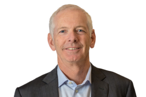  Head-and-shoulders professional portrait of Tim Whiteley with short hair, wearing a collared shirt and blazer, facing the camera against a plain light background