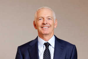  Head-and-shoulders professional portrait of Tim Whiteley with short hair, wearing a collared shirt and blazer, facing the camera against a plain light background