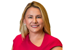 Head-and-shoulders professional portrait of Johanna O'Rourke wearing a short-sleeved top, facing the camera against a plain light background