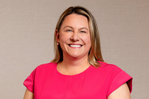 Head-and-shoulders professional portrait of Johanna O'Rourke wearing a short-sleeved top, facing the camera against a plain light background