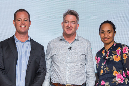 Group of three people standing side by side against a light background