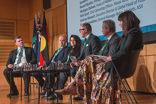 Panel of speakers seated on a stage during a conference session