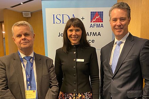 Group of people standing indoors in front of a branded backdrop