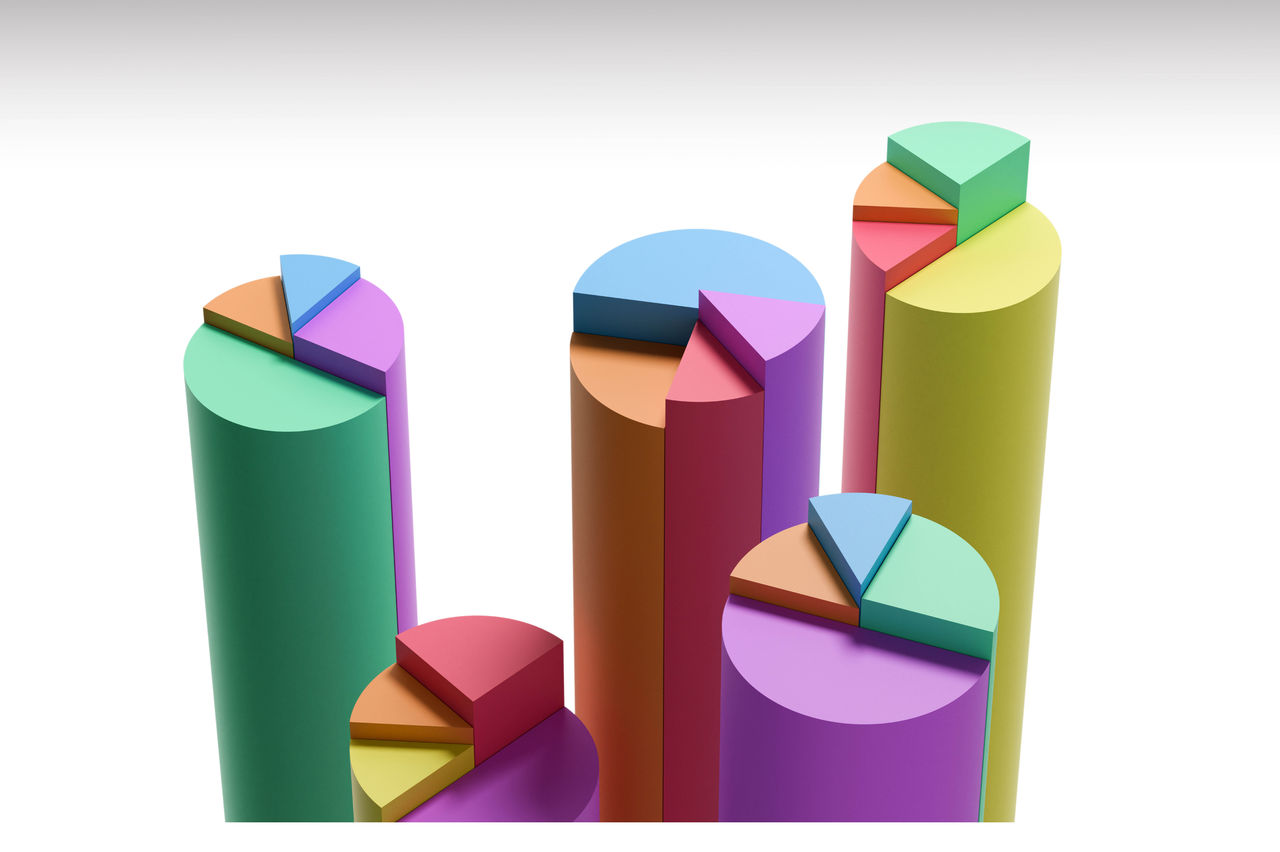 The image shows multiple colorful 3D pie charts placed on top of tall cylindrical columns. 
