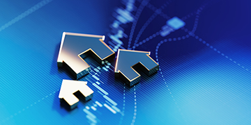Metallic arrows in the shape of a house pointing up on digital financial chart