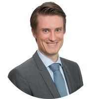 Professional head-and-shoulders portrait of a person wearing a business suit and tie against a plain light background.