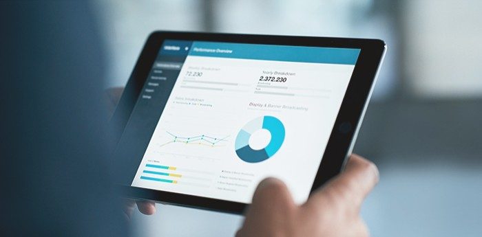 Tablet displaying a business dashboard with charts, graphs and performance metrics.