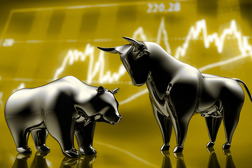 Metal bull and bear on gold background with chart